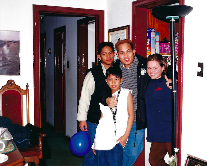 A photo of 4 people standing together in a doorway.