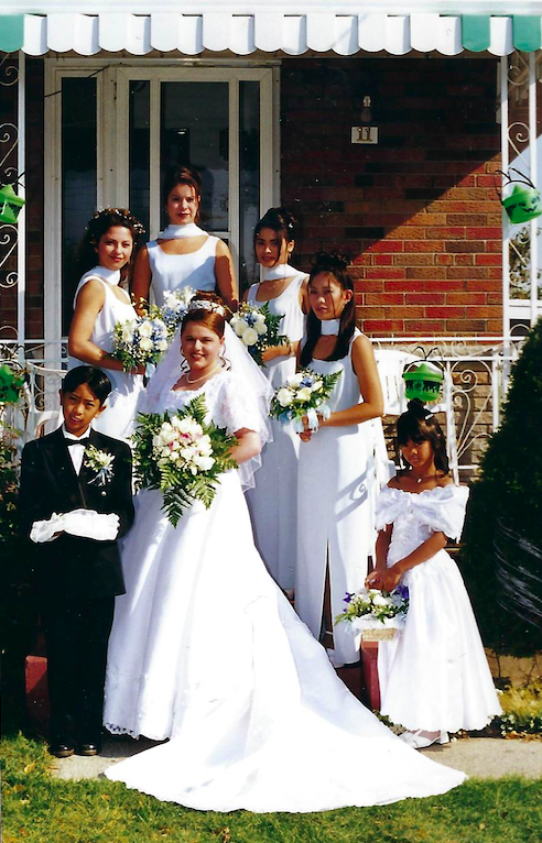 A bridal party standing in front of a house