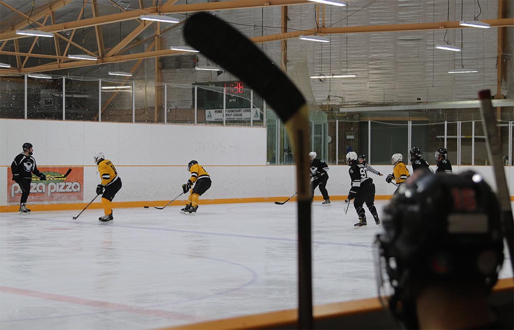 A Toronto Ice Owls blind hockey game is pictured with players on the ice in black and yellow jerseys.
