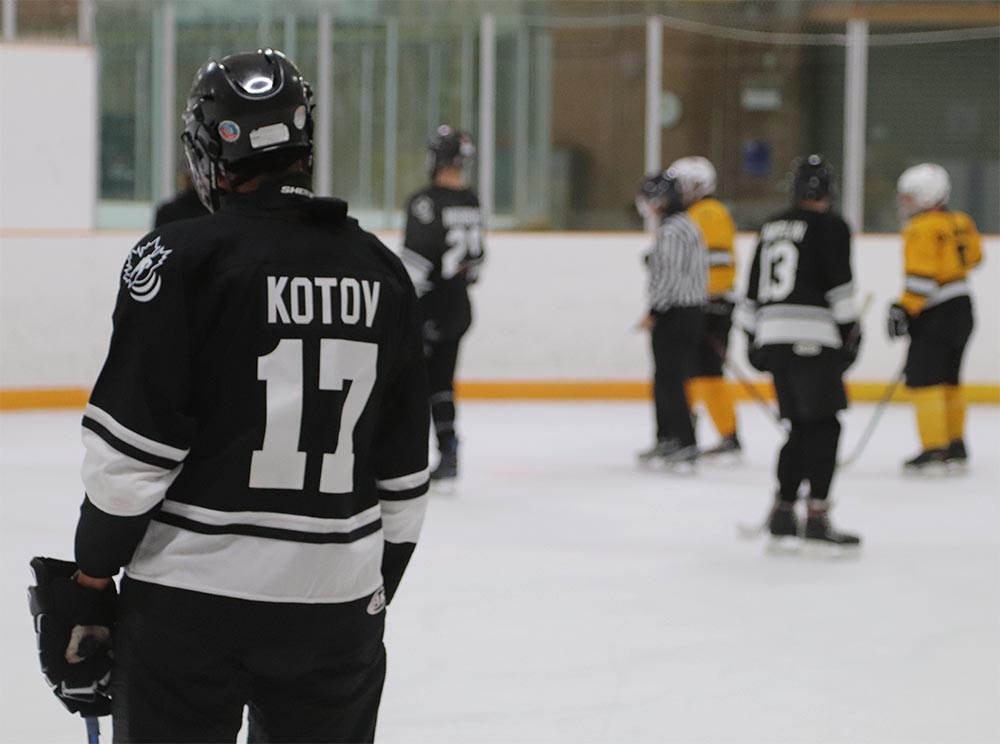Blind hockey player Slava Kotov is pictured from behind displaying his last name and number, 17, on the back of his black jersey.