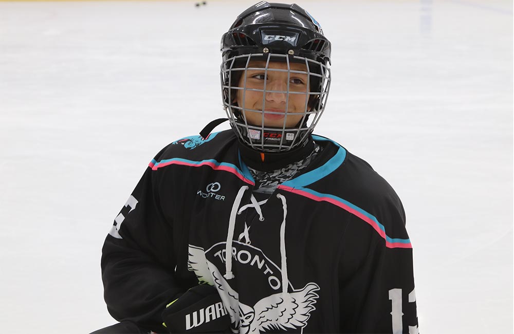 Youth blind hockey player Gabriel Alves is pictured smiling in hockey gear.