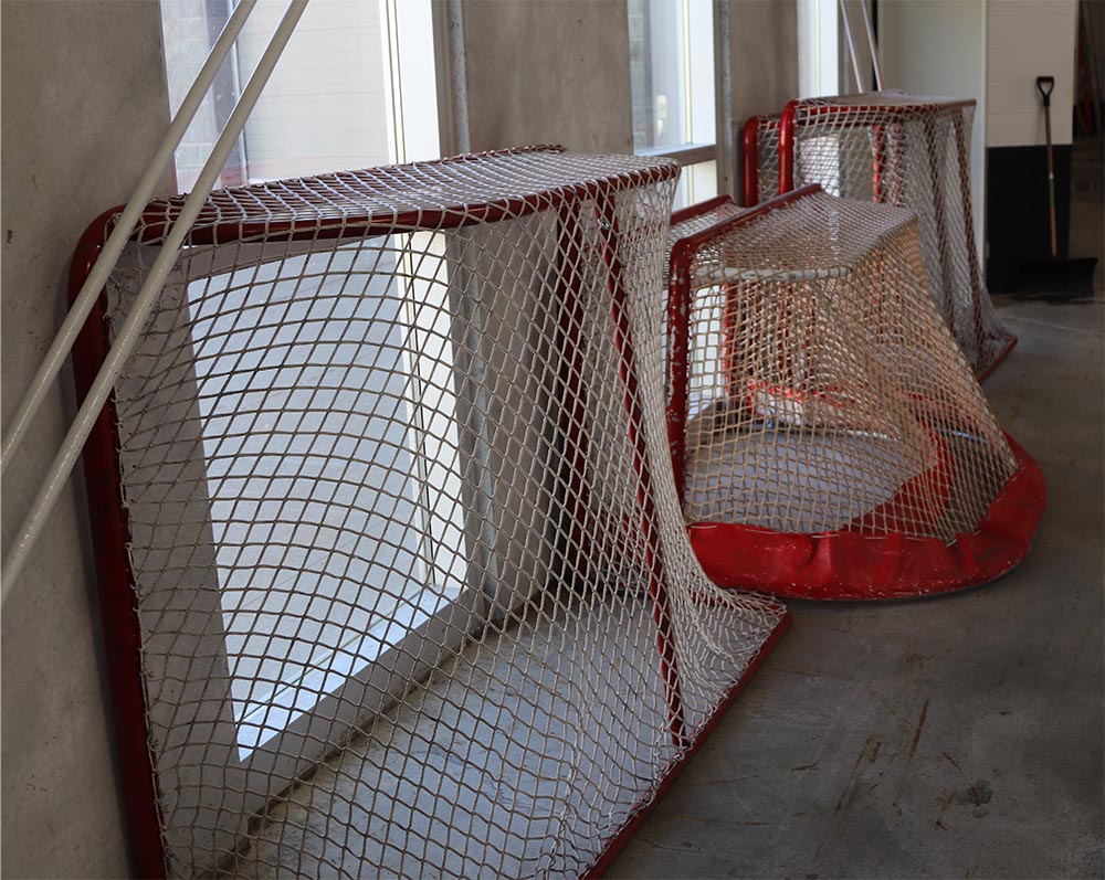 A three-foot blind hockey net is pictured in between two four-foot traditional hockey nets.