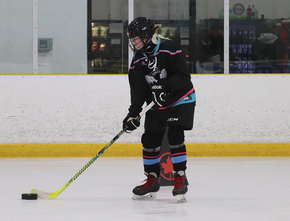 A Toronto Jr. Ice Owls player prepares to take a shot on the ice.