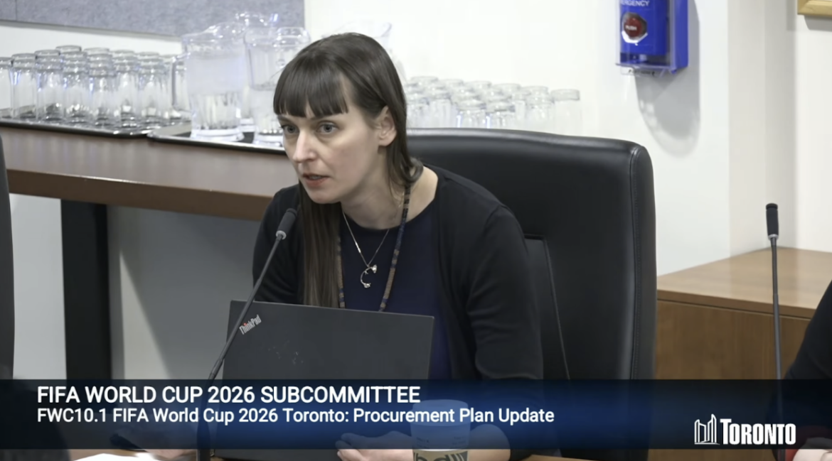 A woman speaks with a laptop in front of her during a FIFA World Cup 2026 Subcommittee session.