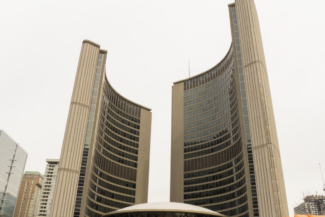 Curved twin towers of Toronto's City Hall, with a low dome structure in the center.